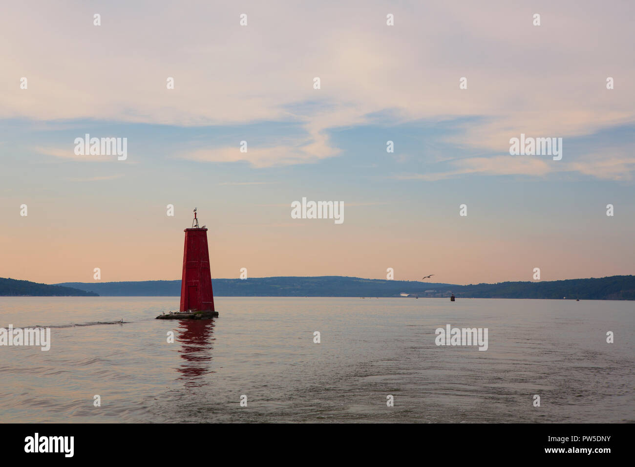 Una grande boa rossa segna l'entrata di Cayuga ingresso off Cayuga Lake, in Ithaca, New York Stato nella regione dei Laghi Finger durante una calma del tramonto. Foto Stock