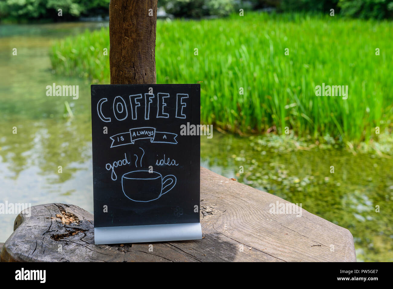 Scheda di colore nero con una iscrizione di caffè sullo sfondo del fiume Korana, Croazia. Con il fuoco selettivo Foto Stock