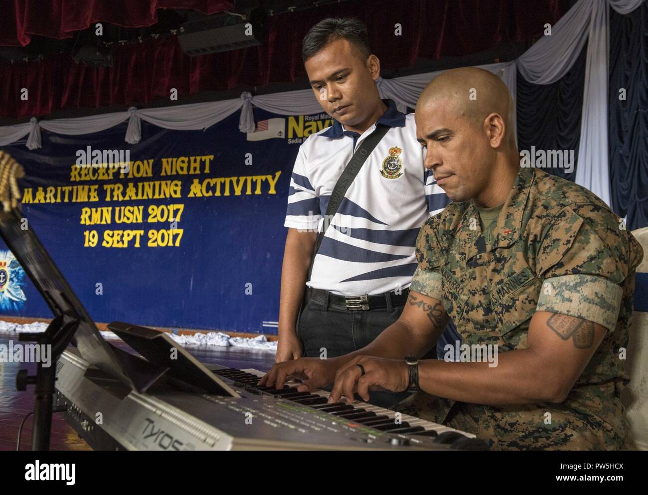 LUMUT, Malaysia (19 settembre 2017) Chief Warrant Officer Andres Navarro della III Marine Expeditionary Force (III) MEF brass band e la Royal Navy malese sailor giocare tastiera durante una comune pratica di banda a Lumut Base Navale come parte della formazione marittima attività (MTA) Malaysia sett. 19, 2017. MTA Malaysia 2017 è una continuazione di 23 anni di impegni marittimi tra Stati Uniti La marina e la Royal Navy malese che serve a migliorare la capacità di reciproca nel garantire la sicurezza marittima e la stabilità. Foto Stock