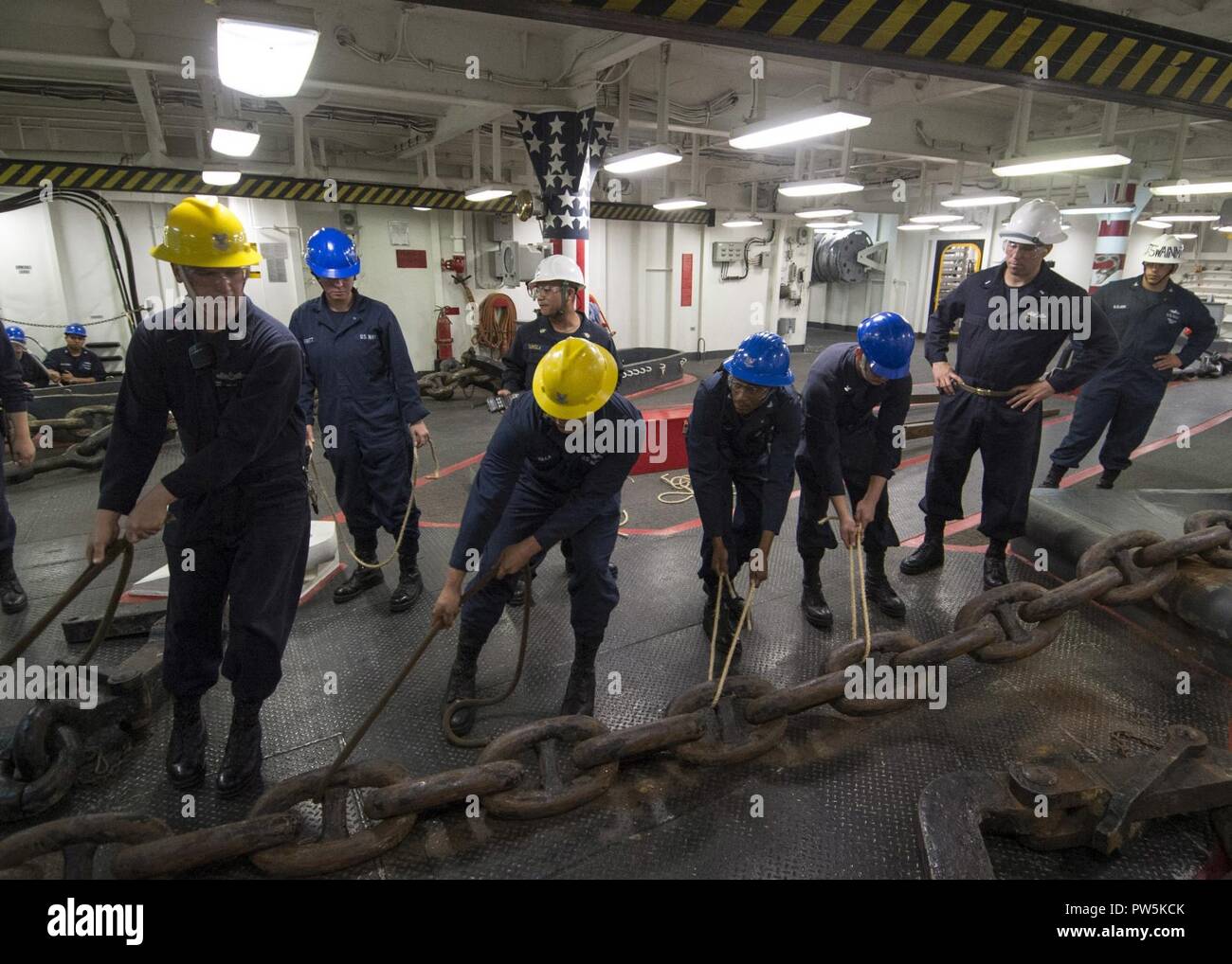 SAN DIEGO (sett. 21, 2017) velisti assegnati all'assalto anfibio nave USS Makin Island (LHD 8) spostare la dritta catena di ancoraggio durante una catena off-load nel castello di prua. Makin Island è attualmente in bacino di carenaggio di General Dynamics National la siderurgia e la costruzione navale Company (NASSCO) per un deposito di manutenzione di livello di disponibilità. Foto Stock