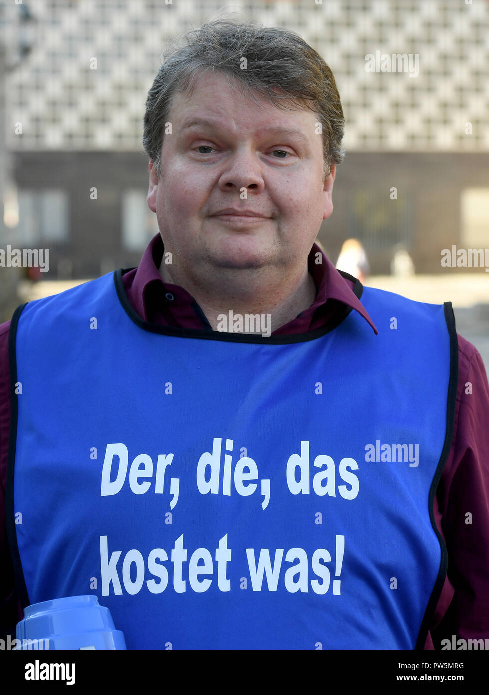 12 ottobre 2018, Bassa Sassonia, Hannover: 12 ottobre 2018, Germania, Hannover: Artur Sieg, altoparlante dell'azione alliance " Il tedesco come lingua straniera", sorge di fronte al Municipio nuovo durante una dimostrazione di educazione degli adulti per i docenti. Circa 50 insegnanti di lingua privata o di istruzione degli adulti college della capitale della Bassa Sassonia per protesta meglio pagare in corsi di istruzione e di educazione degli adulti. I canoni e gli stipendi degli insegnanti di educazione degli adulti sono al livello degli anni novanta e quindi ben al di sotto della media di utile netto in Germania. (A dpa "maestro di seconda classe? - La protesta dei docenti fr Foto Stock