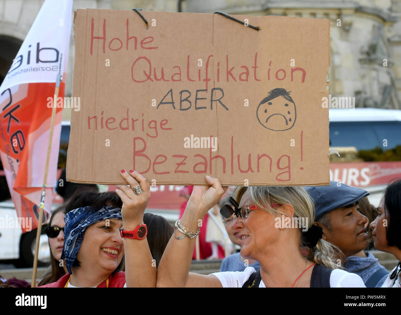 12 ottobre 2018, Bassa Sassonia, Hannover: 12 ottobre 2018, Germania, Hannover: due docenti di tenere un poster con la scritta 'elevata qualificazione ma bassa retribuzione' nelle loro mani. Circa 50 insegnanti di lingua privata o di istruzione degli adulti college della capitale della Bassa Sassonia per protesta meglio pagare in corsi di istruzione e di educazione degli adulti. I canoni e gli stipendi degli insegnanti di educazione degli adulti sono al livello degli anni novanta e quindi ben al di sotto della media di utile netto in Germania. (A dpa "maestro di seconda classe? - La protesta dei professori di educazione degli adulti" del 12.10.2018) Foto: Holger Hollemann/dpa Foto Stock