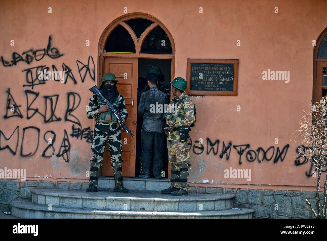 Ottobre 13, 2018 - Srinagar, J&K, India - Un uomo cammina per un seggio di voto durante la terza fase delle elezioni locali in Srinagar, Indiano Kashmir amministrato. La terza fase del Jammu e Kashmir urbano corpo locale elezioni ha cominciato attraverso 300 seggi alle 6 di mattina del sabato in mezzo alle severe misure di sicurezza. Come molti come 365 candidati sono in mischia per le elezioni. Una spessa coltre di sicurezza è stata gettata intorno ai seggi, mentre le forze di sicurezza stanno conducendo dominazione area di esercizi per garantire un incidente-libera elezione, hanno detto i funzionari. (Credito Immagine: © Saqib Majeed/ Foto Stock