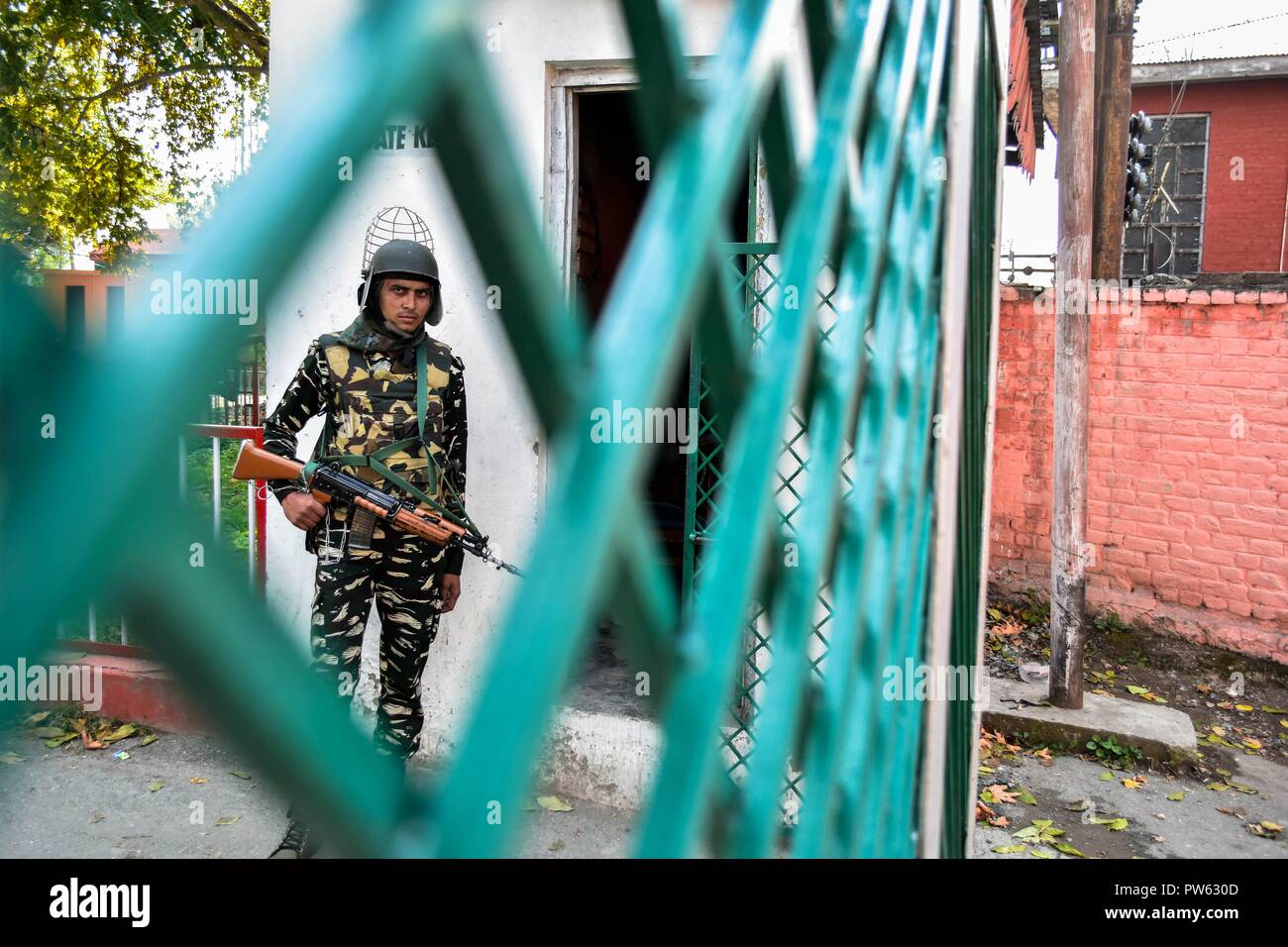 Ottobre 13, 2018 - Srinagar, J&K, India - un soldato di paramilitari veglia mantiene al di fuori della stazione di polling durante la terza fase delle elezioni locali in Srinagar, Indiano Kashmir amministrato. La terza fase del Jammu e Kashmir urbano corpo locale elezioni ha cominciato attraverso 300 seggi alle 6 di mattina del sabato in mezzo alle severe misure di sicurezza. Come molti come 365 candidati sono in mischia per le elezioni. Una spessa coltre di sicurezza è stata gettata intorno ai seggi, mentre le forze di sicurezza stanno conducendo dominazione area di esercizi per garantire un incidente-libera elezione, hanno detto i funzionari. (Credito Foto Stock