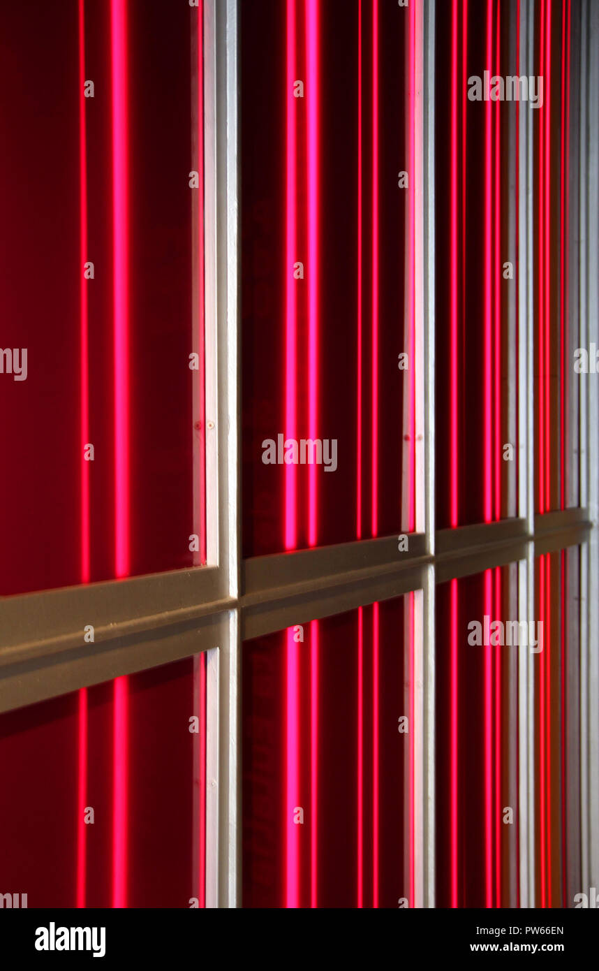 Geometrica insolita caratteristica architettonica fatta di una striscia di alluminio e rosso di illuminazione al neon Foto Stock