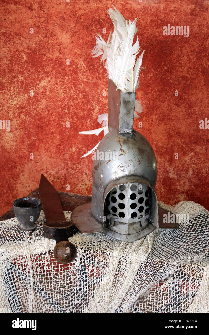 Acciaio gladiatore romano casco, con una spada corta di " Gladius', su una rete Foto Stock