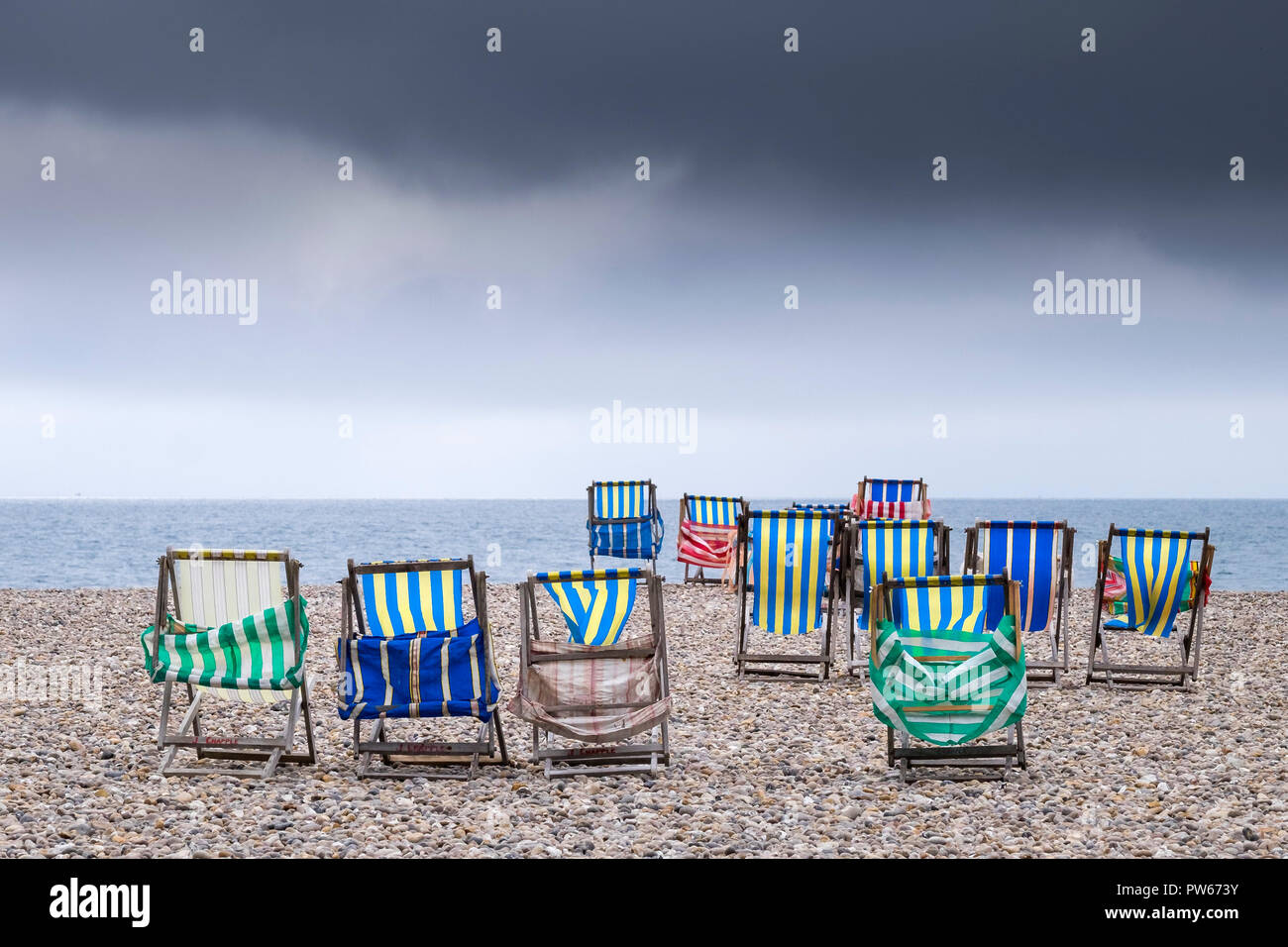 Svuotare sdraio sulla spiaggia di ciottoli di birra nel Devon. Foto Stock