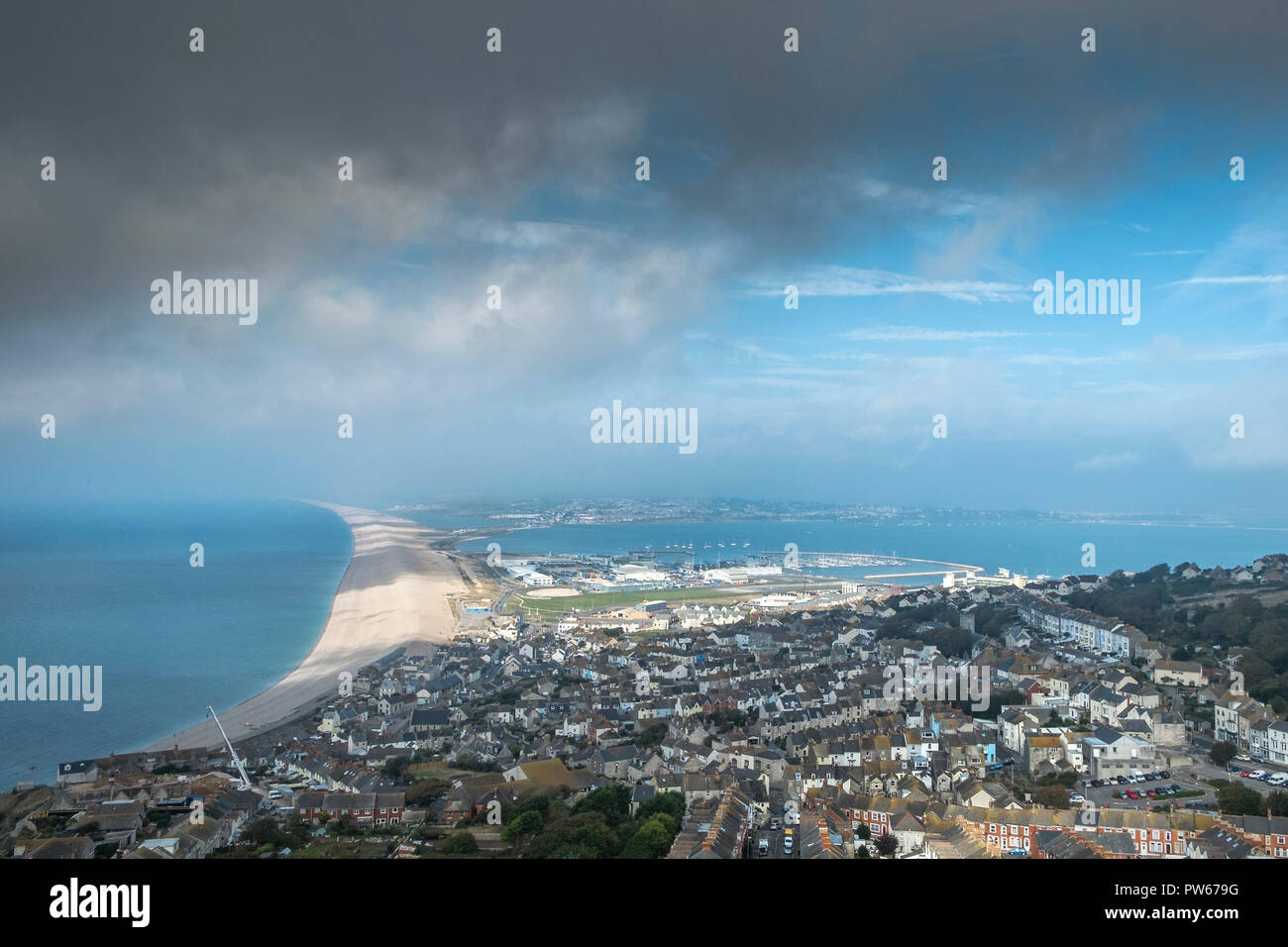 Chesil Beach e case visto dalla vetta del isola di Portland nel Dorset nel Regno Unito. Foto Stock