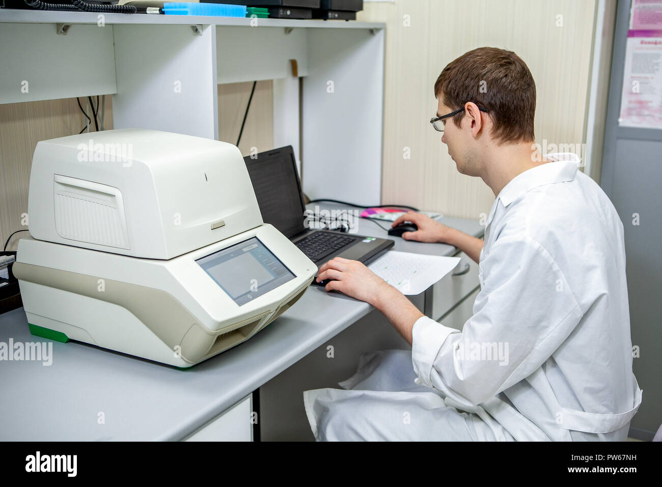 Specialisti di laboratorio esamina i dati ottenuti su una speciale apparecchiatura per analisi di campioni su un computer Foto Stock