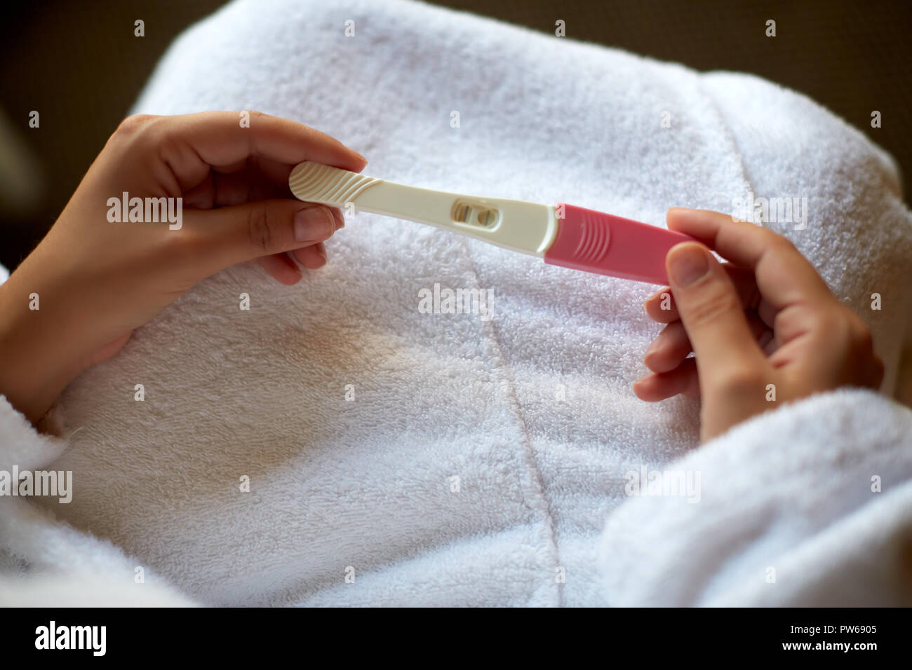 Ragazza con un positivo al test di gravidanza nelle mani Foto Stock