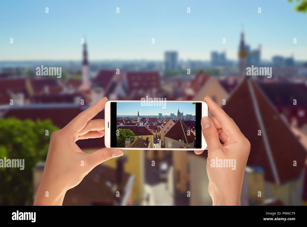 Un turista è di scattare una foto di Tallinn dall'alto in una chiara giornata di sole su un telefono cellulare Foto Stock