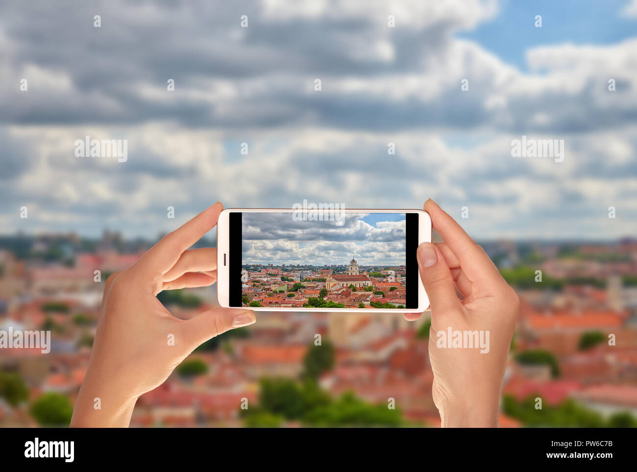 Un turista è scattare una foto della parte storica della città di Vilnius su un telefono cellulare. Foto Stock