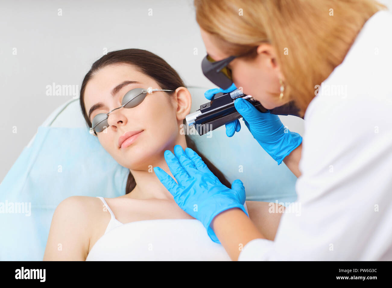 Depilazione laser sul volto di una giovane donna in un cosmetologia Foto Stock