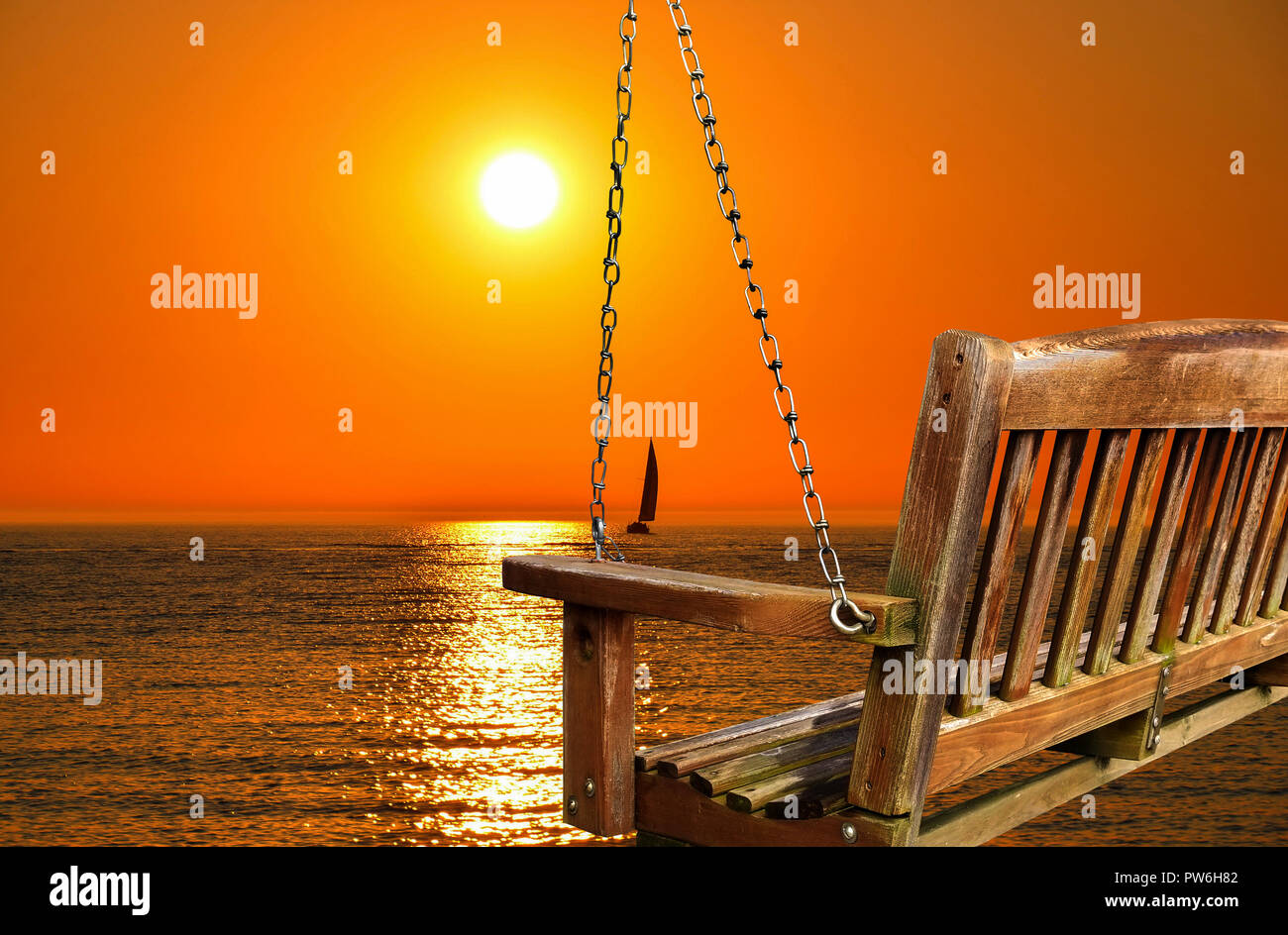 Vuoto swing di legno affacciato sul tramonto sul lago Foto Stock