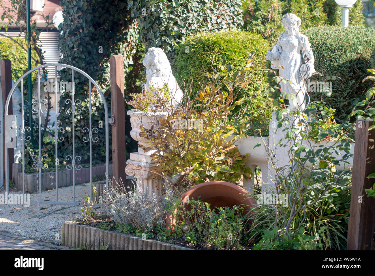 Direzione di viaggio Europa, un giardino pieno di sculture, i fiori e gli alberi in un ristorante italiano in Germania Foto Stock