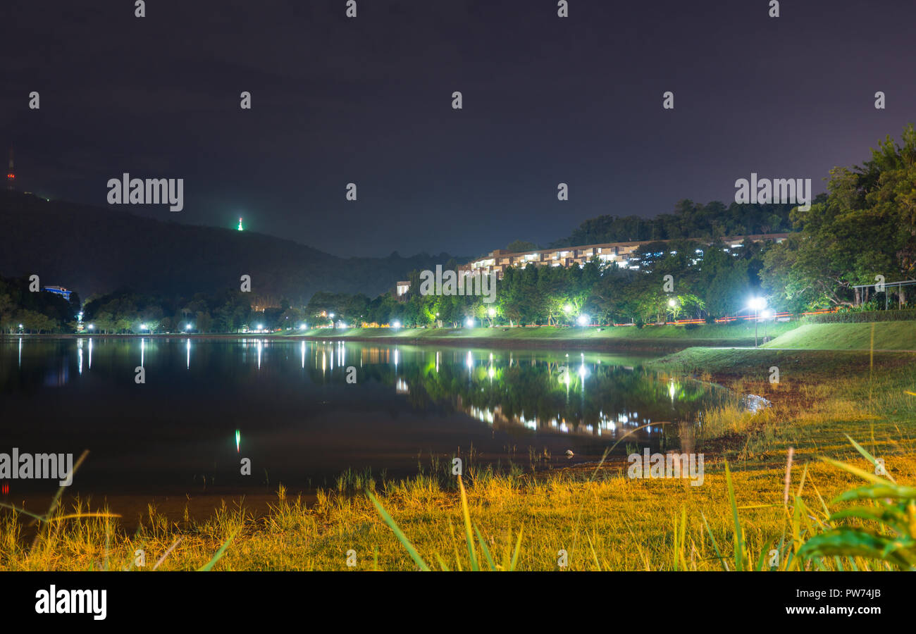 Luce scintillante illuminato la notte, superficie di lago che riflette la luce, leggera brezza soffiava oltre, la vista era spettacolare. Si tratta di un deposito di acqua. Foto Stock