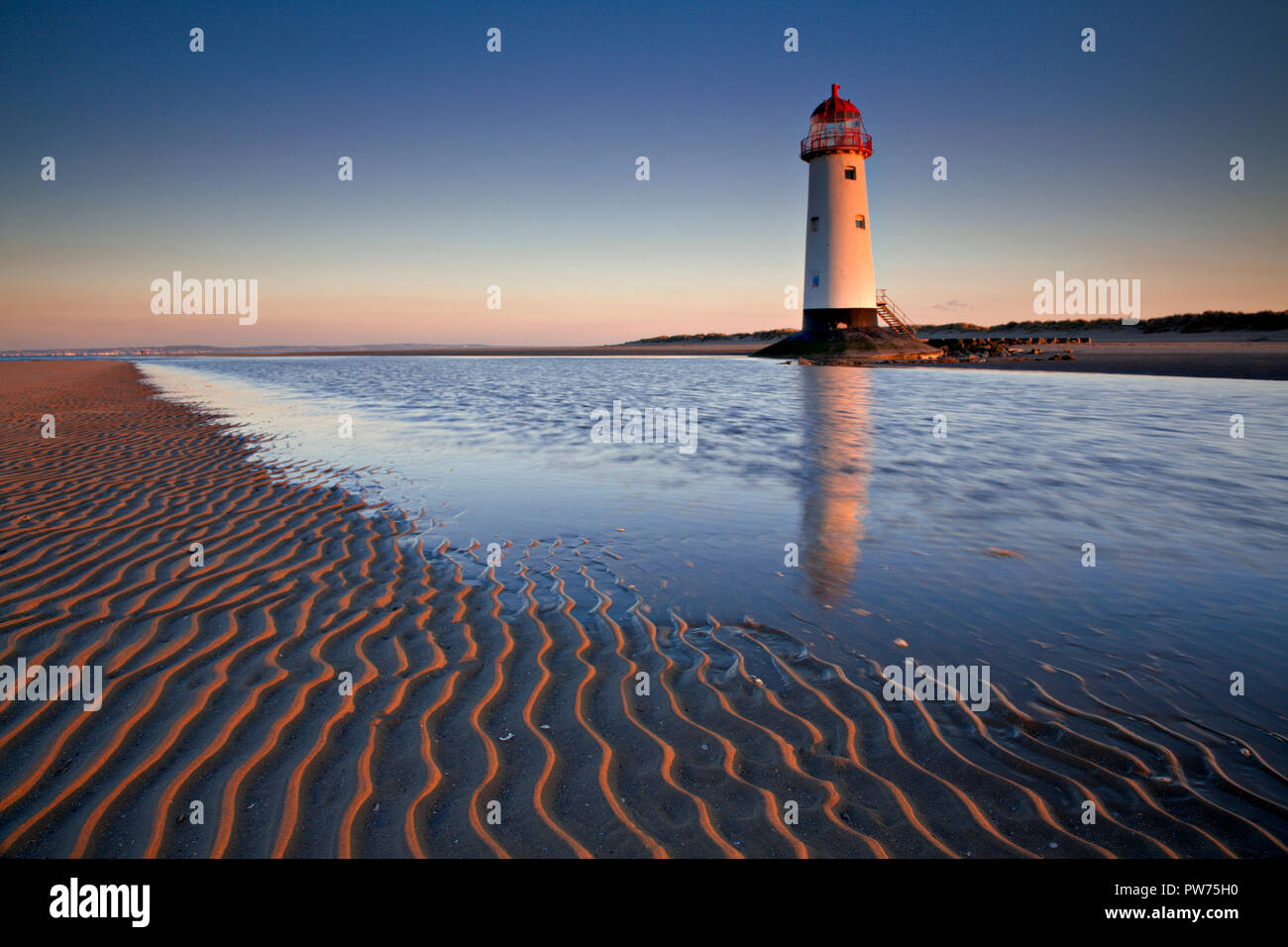 Punto di Ayr faro sulla spiaggia Talacre, costa del Galles Settentrionale riflettendo in un pool di marea Foto Stock