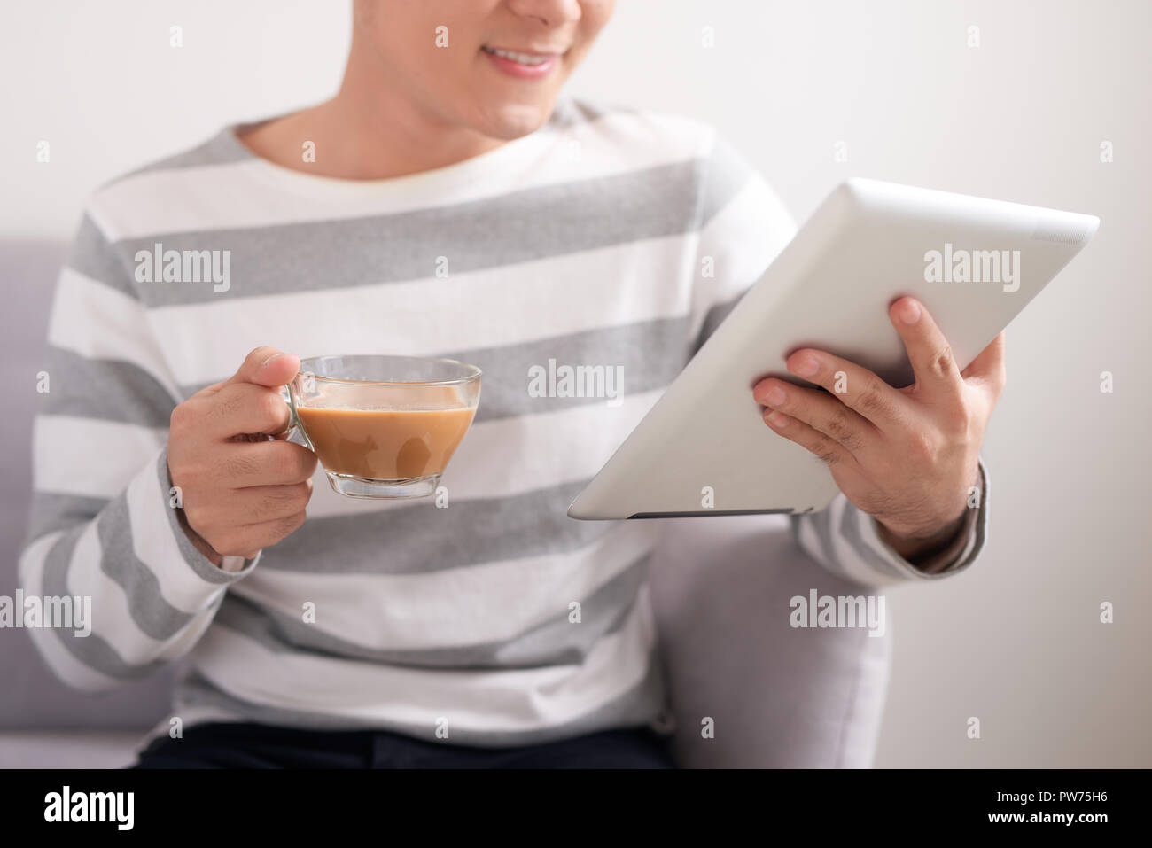 Tecnologia, persone e concetto di piacere - uomo bello con tablet pc e computer cup di bere il caffè o il tè a casa Foto Stock