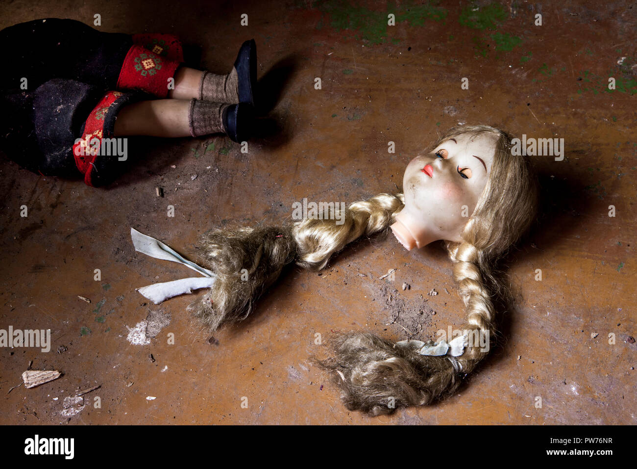 Kuldiga, Lettonia. 19 Agosto, 2014. La rottura di una bambola si trova gettato sul pavimento di una casa abbandonata in Kuldiga, Lettonia. Foto Stock