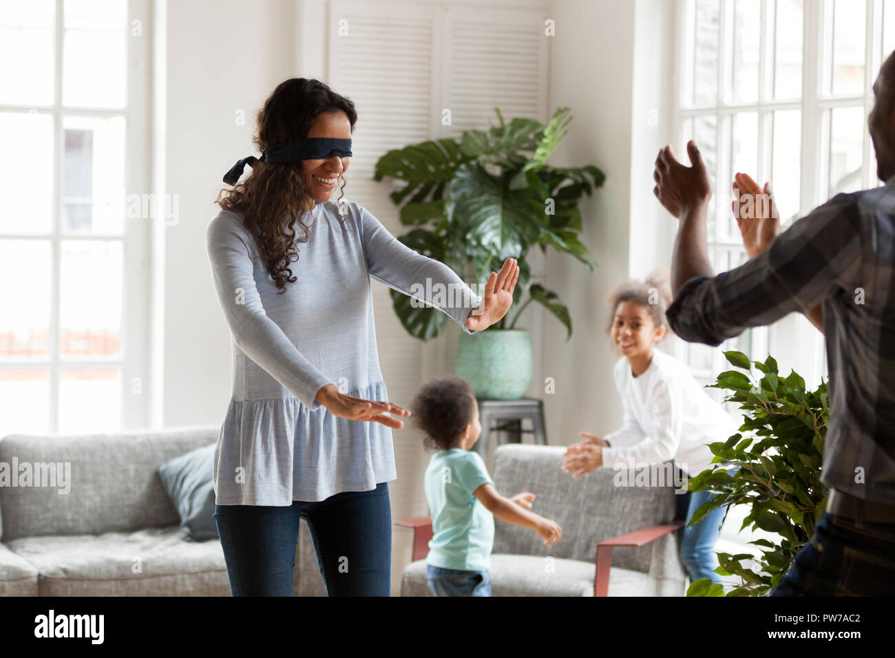Felice nero americano famiglia di giocare a nascondino a casa Foto Stock