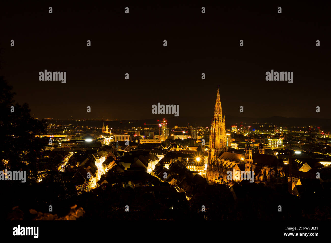 In Germania, di notte le luci su Freiburg im Breisgau e il minster Foto Stock