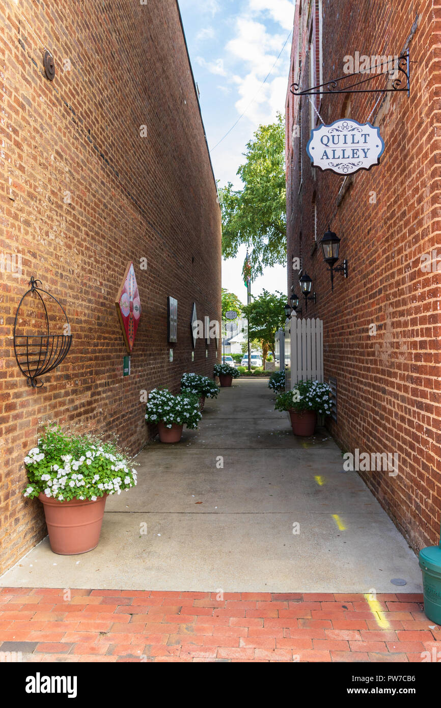 Greeneville, TN, Stati Uniti d'America-10-2-18: un vicolo nel centro cittadino, con vasi di fiori e un "vicolo Quilt segno. Foto Stock