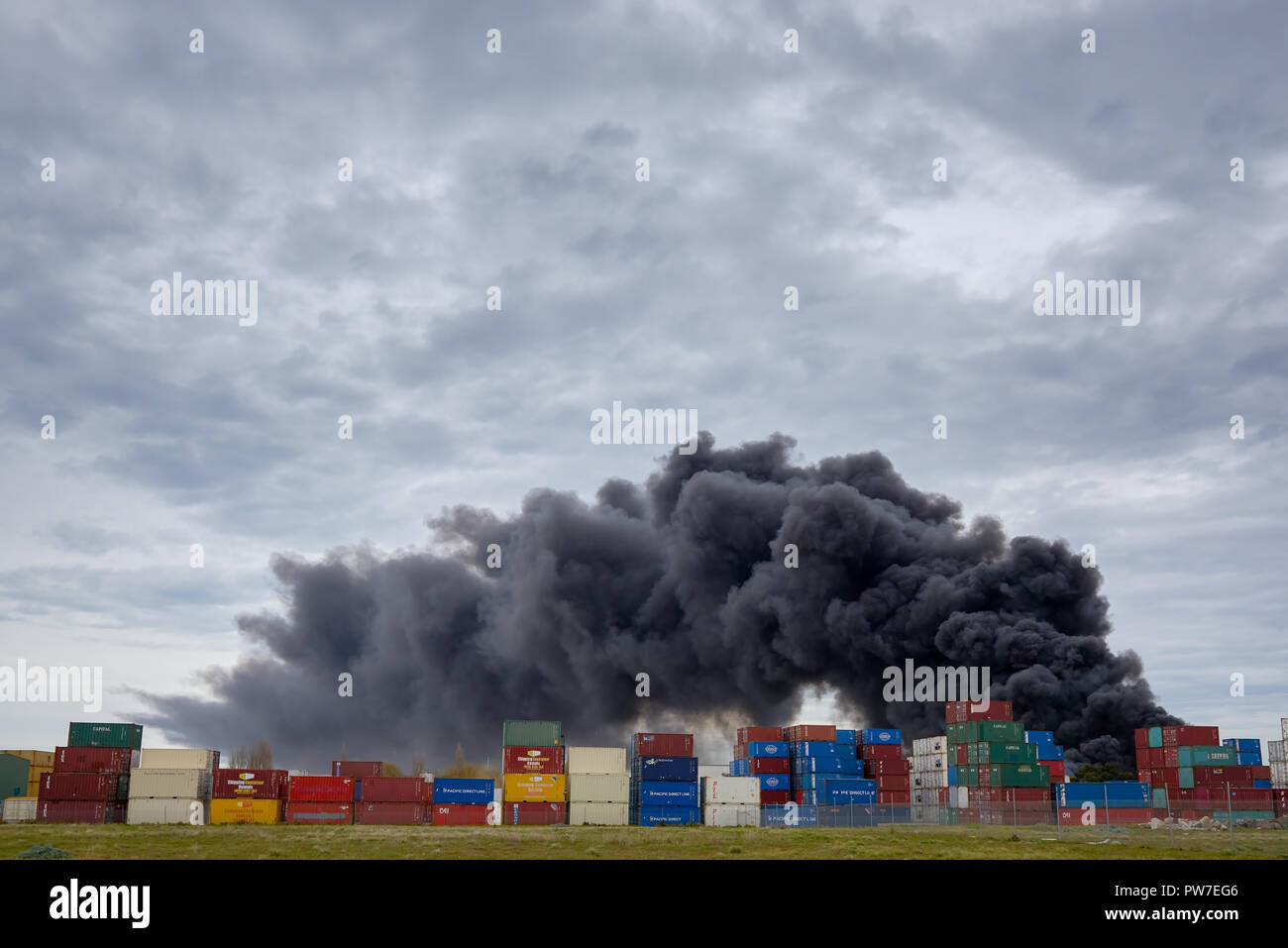 Un pennacchio di fumo tossico a West Footscray incendio in fabbrica come visto da dietro i contenitori di spedizione. Melbourne, Victoria, Australia 30 agosto 2018. Foto Stock