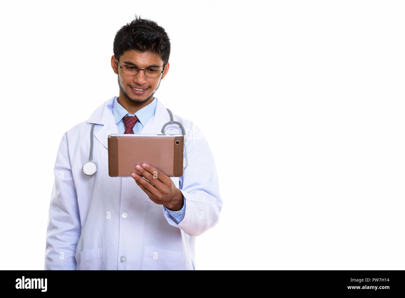 Studio shot di giovani felici uomo indiano medico sorridere mentre holdi Foto Stock