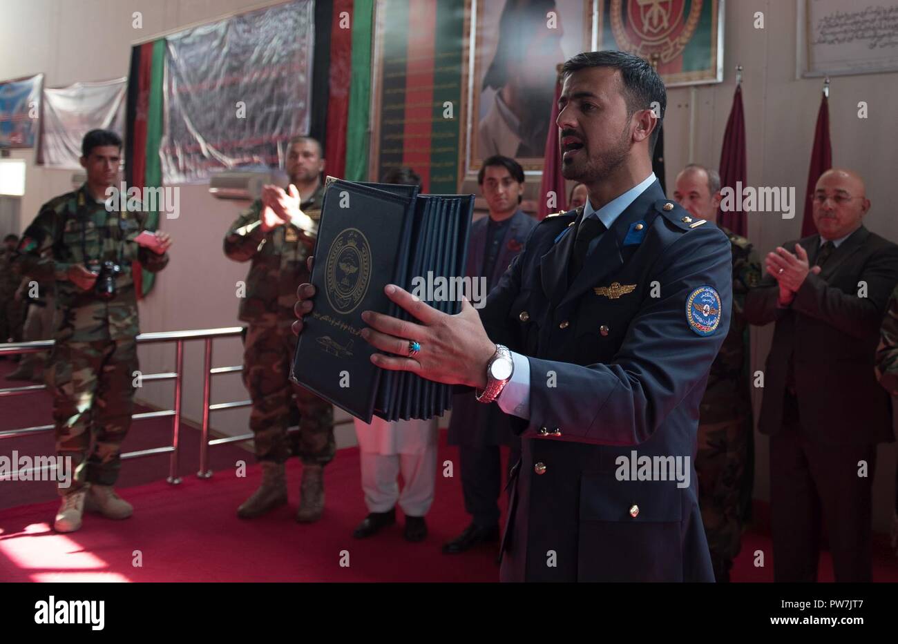 Un laureato della classe 2017 della Afghan Air Force Academy ceremonially presenta i certificati per lui e per i suoi compagni di classe, Sett. 25, 2017, a Kabul, Afghanistan. Nintey-otto cadetti commissionined come luogotenenti e passerà al treno come piloti, operazioni e manutenzione degli ufficiali in Afghanistan del servizio aereo. Foto Stock