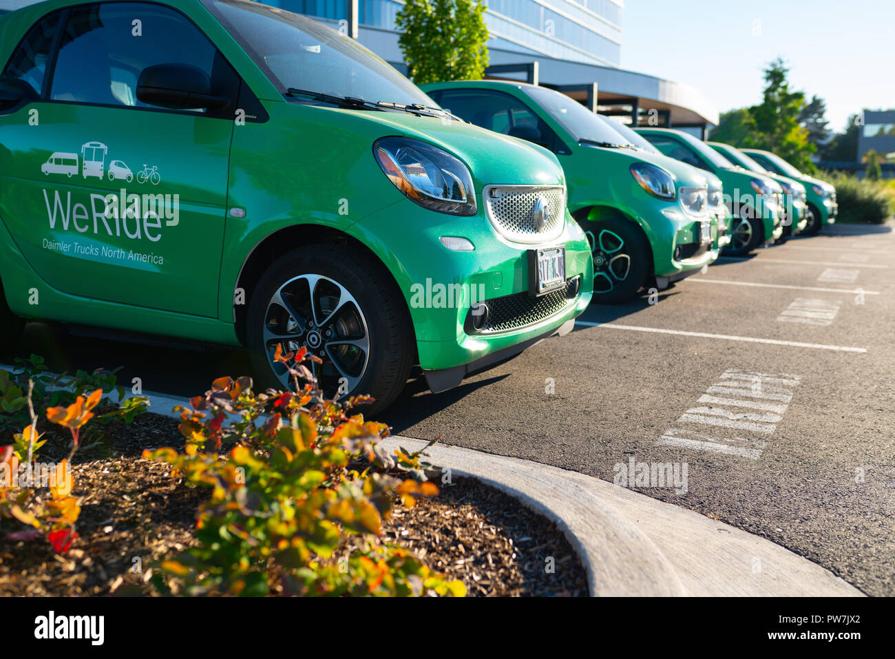 Portland, O / STATI UNITI D'America - 8 Luglio 2018: fila di verde elettrico e-corse auto presso la Daimler per la condivisione tra i dipendenti in situazioni di emergenza. Foto Stock