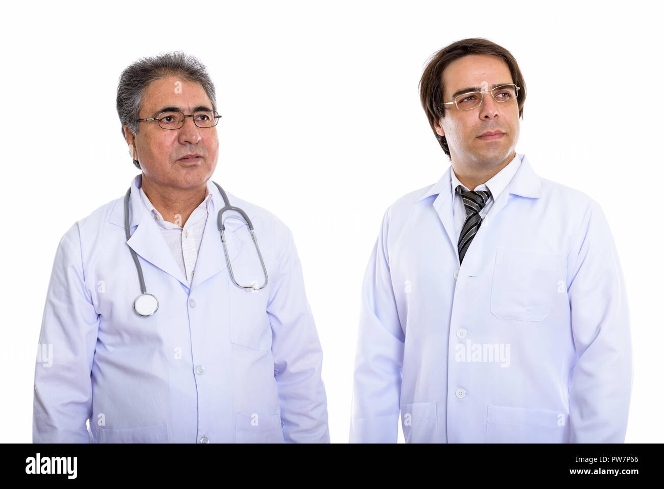 Riflessivo giovani e senior uomo persiano medico guardando distan Foto Stock