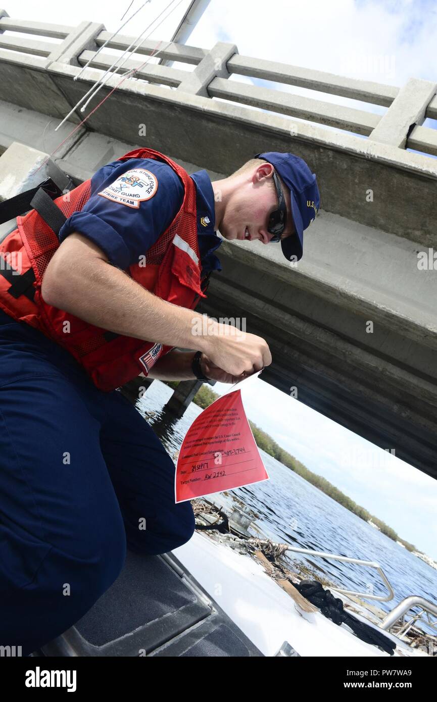 Petty Officer di 2a classe di David Nelson, un Macchinario Tecnico con lo sciopero nazionale vigore, prepara un adesivo di valutazione mentre in corso in chiave di avvio porto, nei pressi di Maratona, Florida, Sett. 29, 2017. Foto Stock