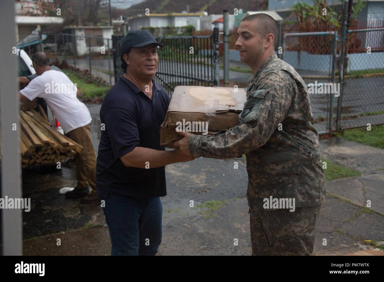 Stati Uniti Army Sgt. Hawley Jonathan, assegnato a 101st combattere la Brigata aerea (cabina), 101st Airborne Division (Air Assault), contribuisce a spostare la tarps nella comunità edificio polifunzionale, Ceiba, Puerto Rico, Sett. 30, 2017. La tarps sono utilizzate per fissare temporaneamente i tetti delle case colpite dalla tempesta. La 101st cabina è in conduzione evacuazione medica e i soccorsi per supportare la FEMA nel processo di recupero di Puerto Rico dopo la devastazione creata dall uragano Maria. Foto Stock Stati Uniti Army Sgt. Hawley Jonathan, assegnato a 101st combattere la Brigata aerea (cabina), 101st Airborne Division (Air Assault), contribuisce a spostare la tarps nella comunità edificio polifunzionale, Ceiba, Puerto Rico, Sett. 30, 2017. La tarps sono utilizzate per fissare temporaneamente i tetti delle case colpite dalla tempesta. La 101st cabina è in conduzione evacuazione medica e i soccorsi per supportare la FEMA nel processo di recupero di Puerto Rico dopo la devastazione creata dall uragano Maria. Foto Stock