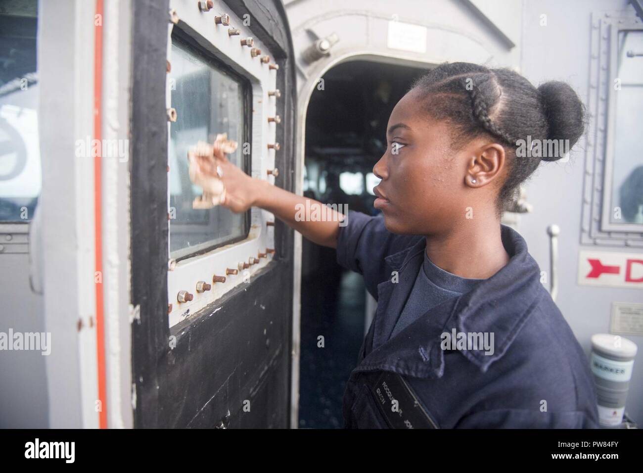 5TH FLOTTA AREA DI OPERAZIONI (sett. 24, 2017) Quartermaster marinaio Rocquel Jones, nativo di Kansas City, assegnato alla navigazione/dipartimento amministrazione a bordo del dock anfibio sbarco nave USS Pearl Harbor (LSD 52), pulisce le finestre sul ponte durante un rifornimento in mare (RAS) con Lewis e Clark-secco classe nave cargo USNS Washington Camere (T-AKE 11). Pearl Harbor è parte dell'America anfibio gruppo pronto (ARG) e, con l'avviato xv Marine Expeditionary Unit (MEU), è distribuito come supporto di le operazioni di sicurezza marittima e di teatro di sicurezza gli sforzi di cooperazione Foto Stock 5TH FLOTTA AREA DI OPERAZIONI (sett. 24, 2017) Quartermaster marinaio Rocquel Jones, nativo di Kansas City, assegnato alla navigazione/dipartimento amministrazione a bordo del dock anfibio sbarco nave USS Pearl Harbor (LSD 52), pulisce le finestre sul ponte durante un rifornimento in mare (RAS) con Lewis e Clark-secco classe nave cargo USNS Washington Camere (T-AKE 11). Pearl Harbor è parte dell'America anfibio gruppo pronto (ARG) e, con l'avviato xv Marine Expeditionary Unit (MEU), è distribuito come supporto di le operazioni di sicurezza marittima e di teatro di sicurezza gli sforzi di cooperazione Foto Stock