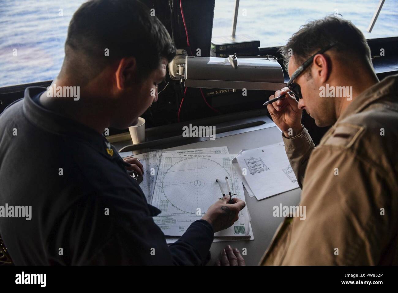 Mare Mediterraneo (ott. 2, 2017) Quartermaster 1a classe Filippo ciuffi, sinistra e alfiere di Craig Borden creare una scheda di manovra sul ponte del San Antonio-classe di trasporto anfibio dock nave USS San Diego (LPD 22). San Diego è distribuito con l'America anfibio gruppo pronto e il quindicesimo Marine Expeditionary Unit (XV MEU) per il supporto di sicurezza marittima e di teatro la cooperazione in materia di sicurezza negli sforzi negli Stati Uniti Sesta flotta area di operazioni. Foto Stock