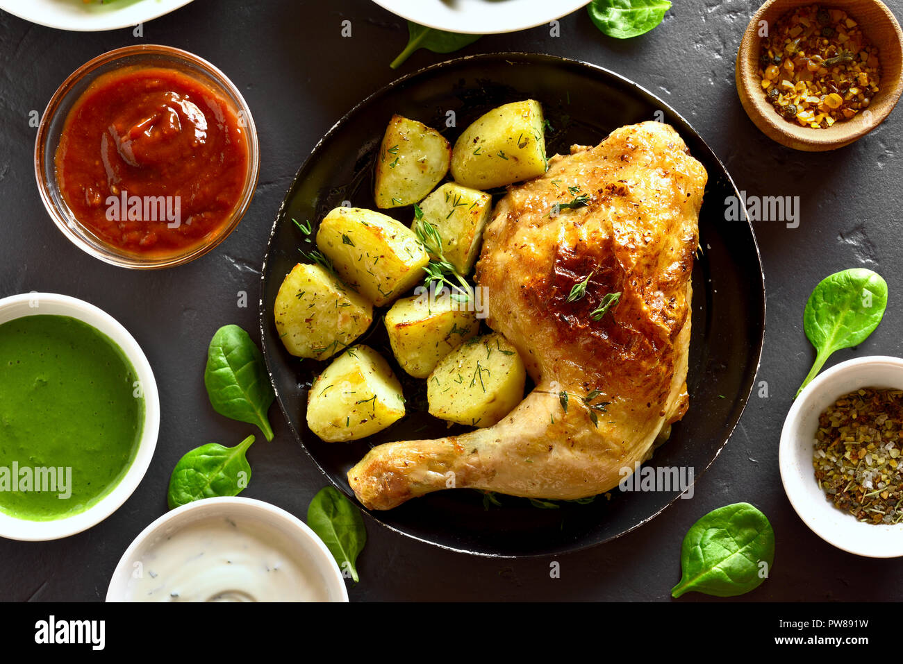 Il pollo al forno della gamba con patate e salsa. Piatto per la cena. Vista superiore, laici piatta Foto Stock