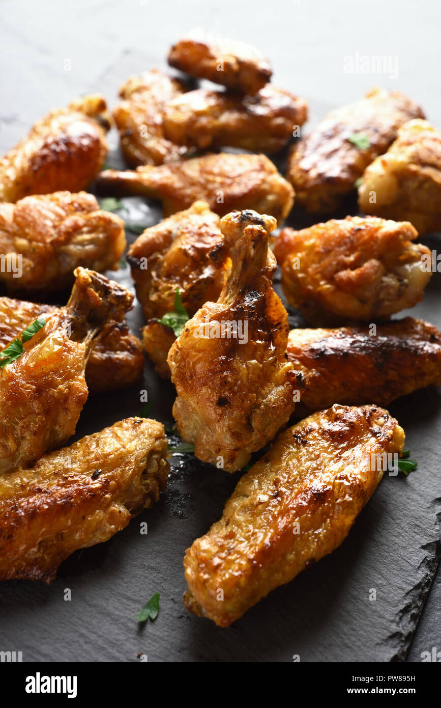 Grigliata di ali di pollo sulla scheda di pietra. Il cibo gustoso per cena Foto Stock