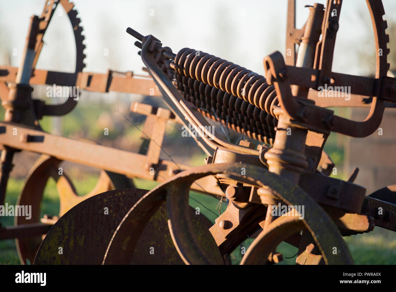 Vecchie e arrugginite farm machinery seduti in un paddock presso la cantina Rowlee in Nashdale vicino a Orange, Nuovo Galles del Sud, Australia Foto Stock