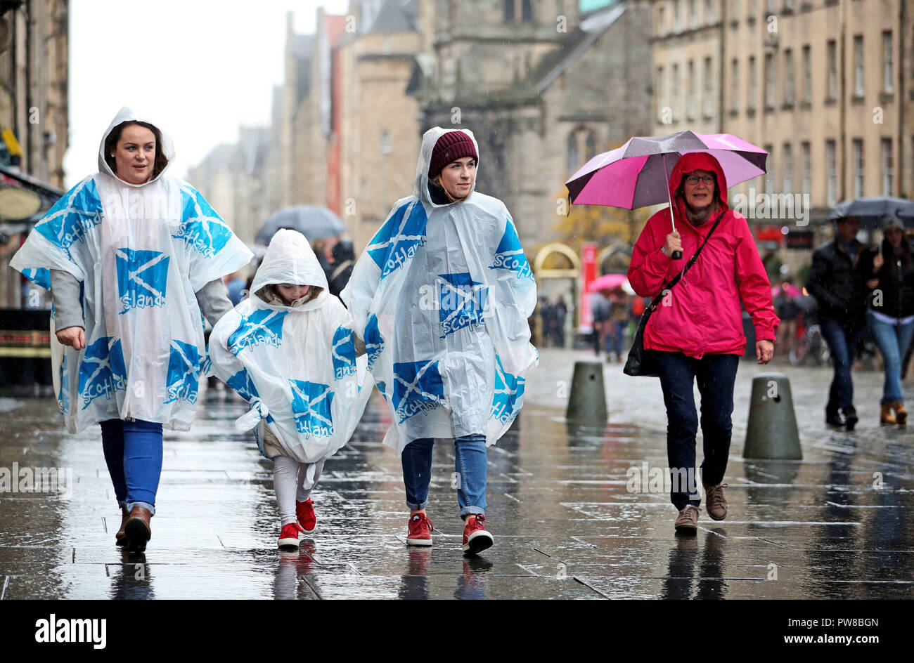 I turisti che indossa poncho di emergenza su Edinburgh Royal Mile. Foto Stock