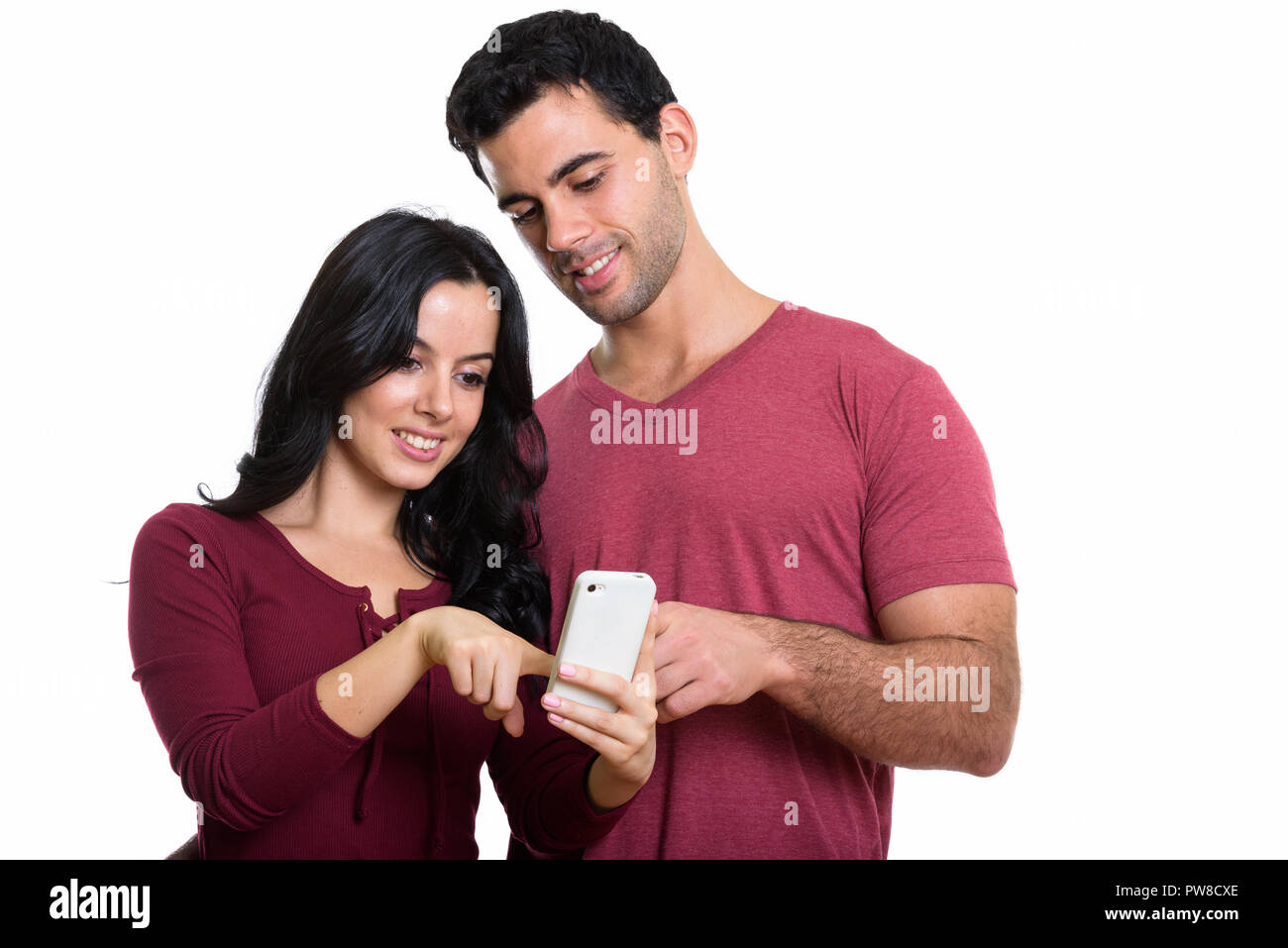 Studio shot della giovane coppia felice sorridere mentre utilizzando un mobile Foto Stock