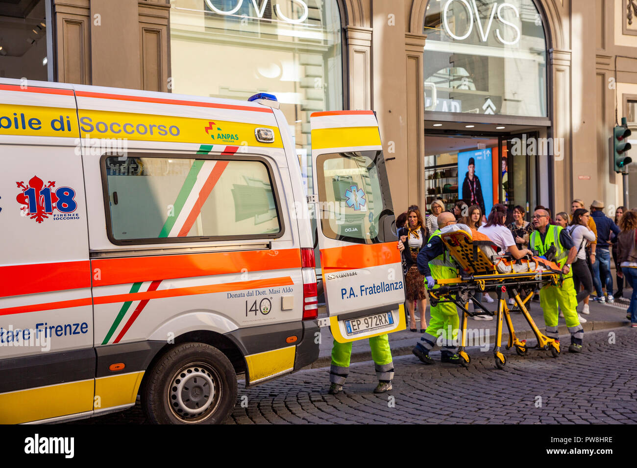 Feriti lady essendo aiutato in un ambulanza italiana da personale sanitario paramedici in Firenze e Toscana Foto Stock