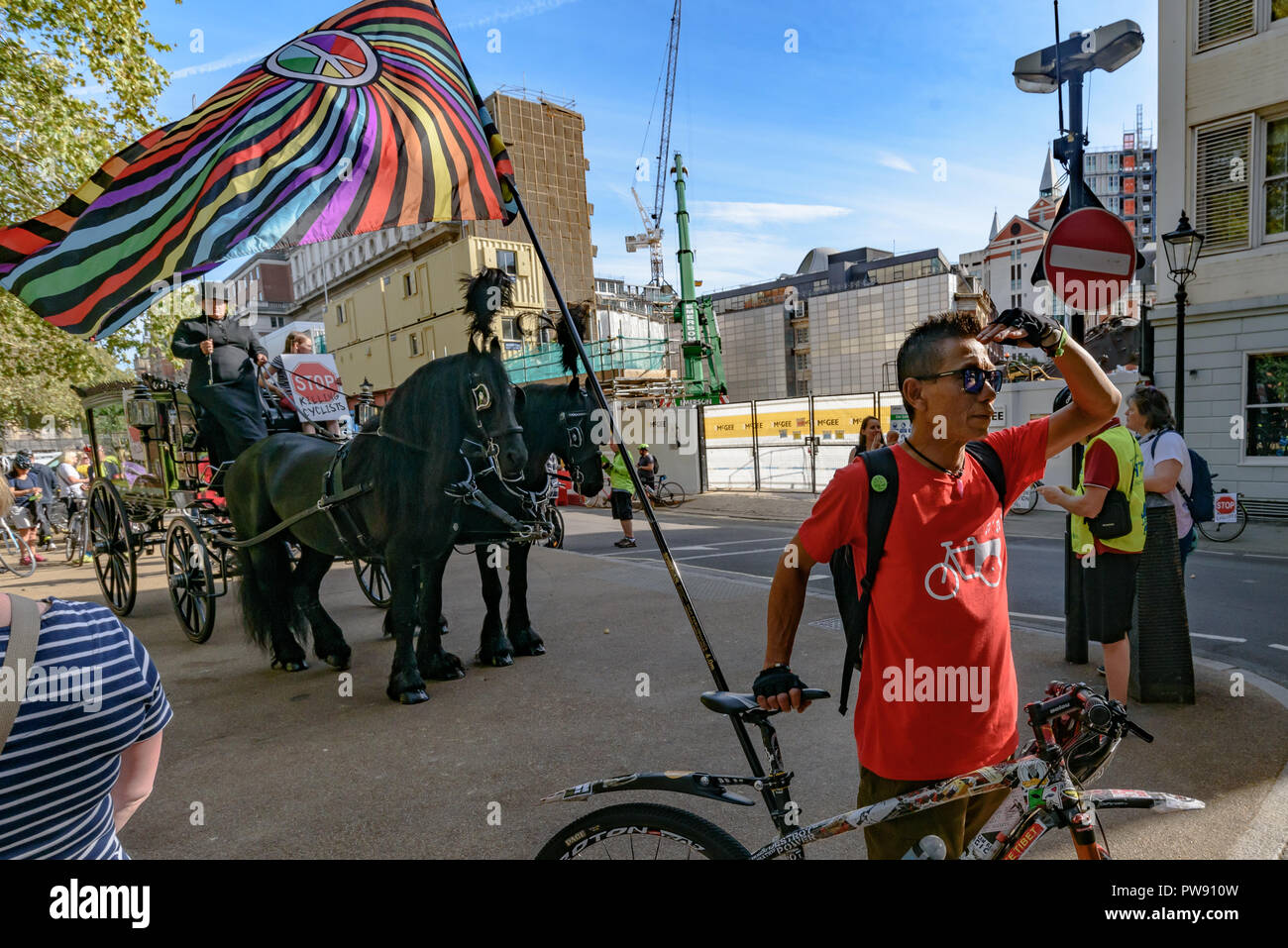 Londra, Regno Unito. 13 ottobre 2018. La gente in attesa per l'inizio del corteo funebre dei ciclisti dietro a cavallo funebre per evidenziare il fallimento dei governi di tutte le principali parti di prendere azione completa su safer escursioni in bicicletta. Smettere di uccidere i ciclisti call per £ 3 miliardi di un anno per essere investito in un protetto nazionale di ciclismo e di rete per azioni urgenti per ridurre gli effetti tossici inquinamento atmosferico da emissioni dei motori diesel e i veicoli a benzina che uccide decine di migliaia di persone ogni anno, e disabilita le centinaia di migliaia di persone. Le diverse centinaia di manifestanti hanno inscenato una decina di minuti di die-in al di fuori di questo Parlamento prima di Foto Stock