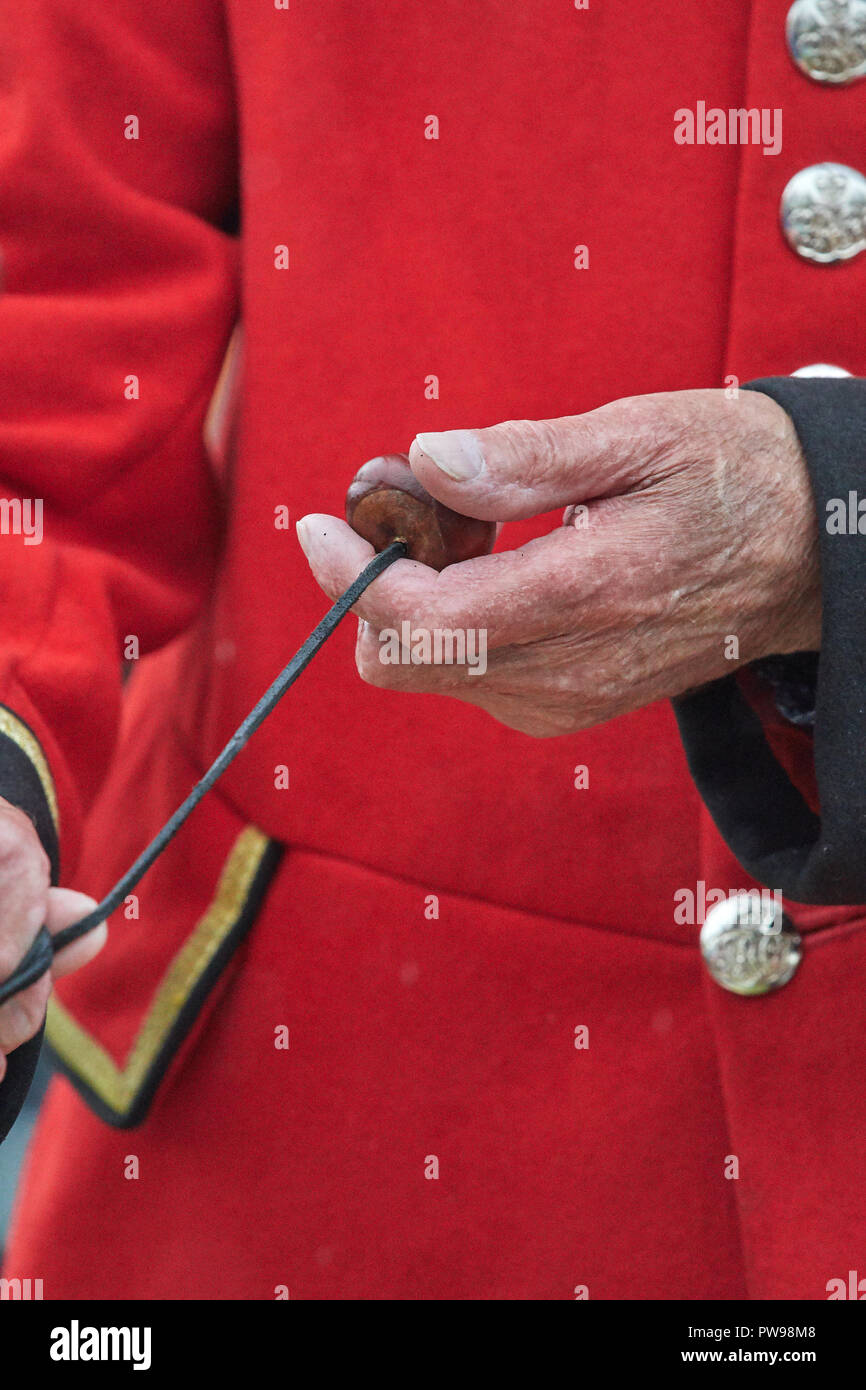 Southwick, UK. Il 14 ottobre 2018. Che regna uomini campione del mondo, John Riley, octogenarian un pensionato di Chelsea, prepara il suo conker per prendere la mira a conker del suo avversario, Roy Palmer (Town Crier per Mablethorpe), nell'apertura bout del 2018 world conker championships in un giorno di pioggia a Southwick, UK; John Riley ha vinto lo scontro. Credito: Michael Foley/Alamy Live News Foto Stock