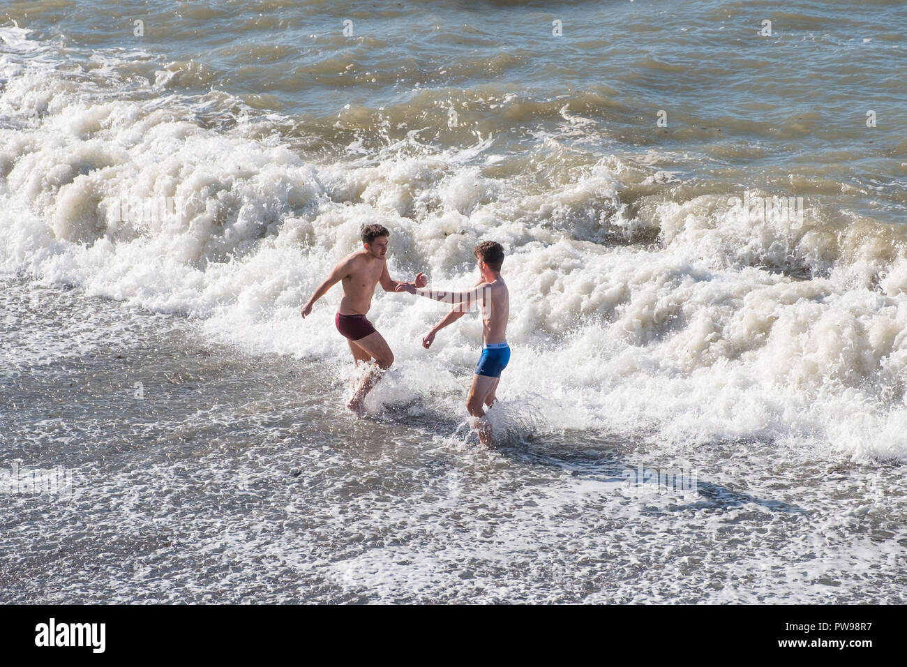 Aberystwyth, UK. Il 14 ottobre 2018. Meteo REGNO UNITO: Gli Studenti nuotare nel mare in un pomeriggio soleggiato in Aberystwyth Wales, in netto contrasto con il tempestoso clima umido dei precedenti tre giorni. Credito: Keith Morris / Alamy Live News Foto Stock