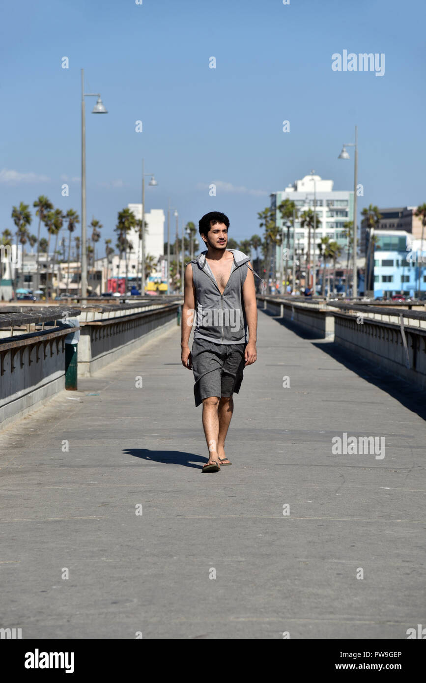 Bel giovane maschio passeggiate turistiche sulla pesca del molo a Venice Beach in California del Sud. Foto Stock