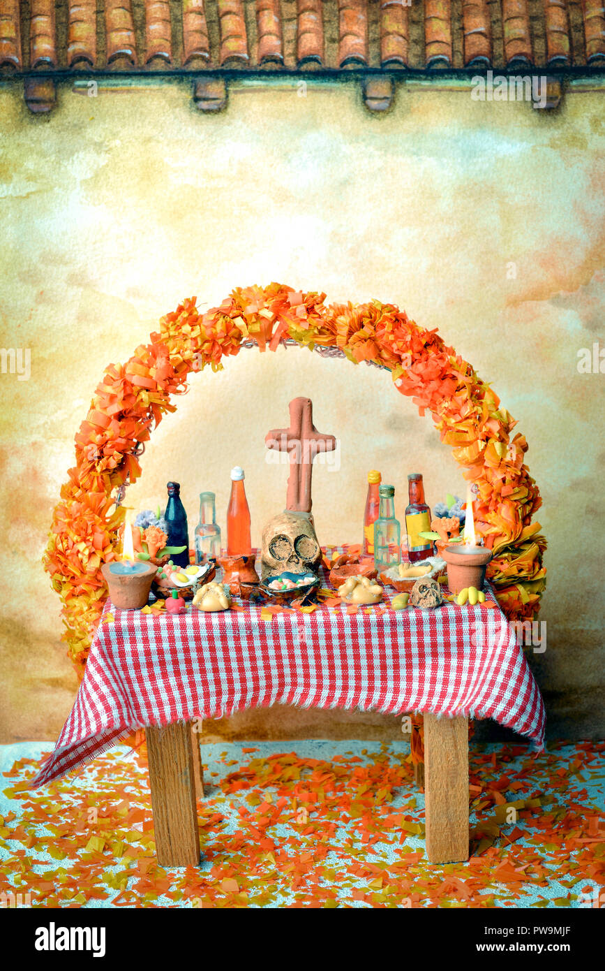 Mexican giorno dei morti altare con cranio, pan de muerto, bevande, cempasuchil fiori e candele Foto Stock