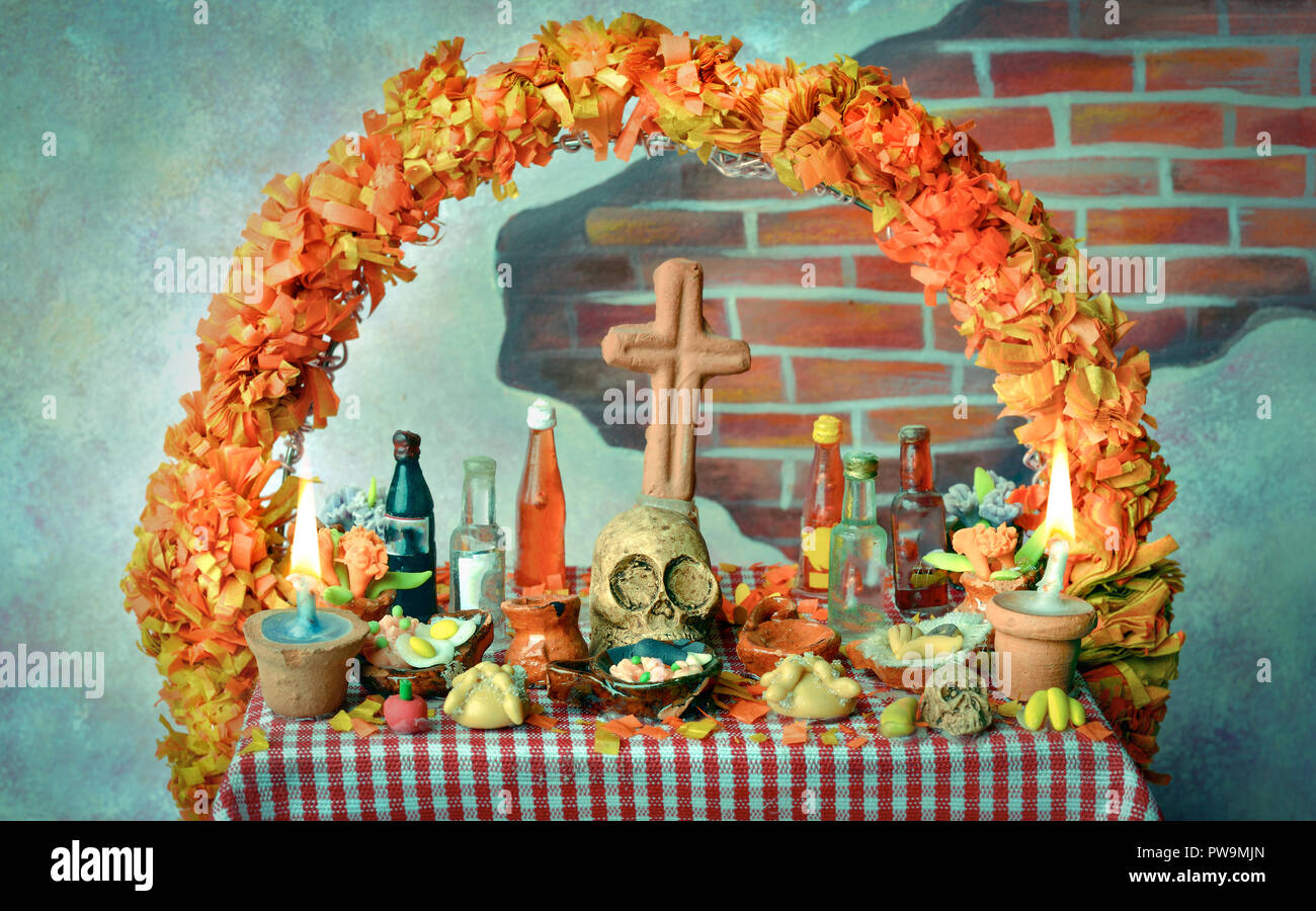 Mexican giorno dei morti altare con cranio, pan de muerto, bevande, cempasuchil fiori e candele Foto Stock