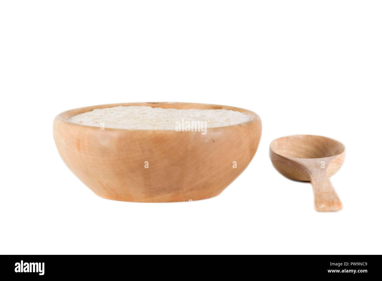 Ciotola di legno di porridge con cucchiaio isolato su sfondo bianco Foto Stock