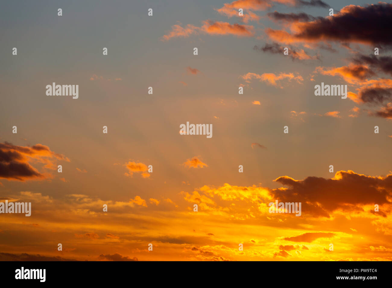 Raggi crepuscolari, talvolta noto come raggi di Dio, tra le nuvole arancione al tramonto durante il mese di settembre. Preso da osono paludi Riserva Naturale, Kent, Regno Unito. Foto Stock