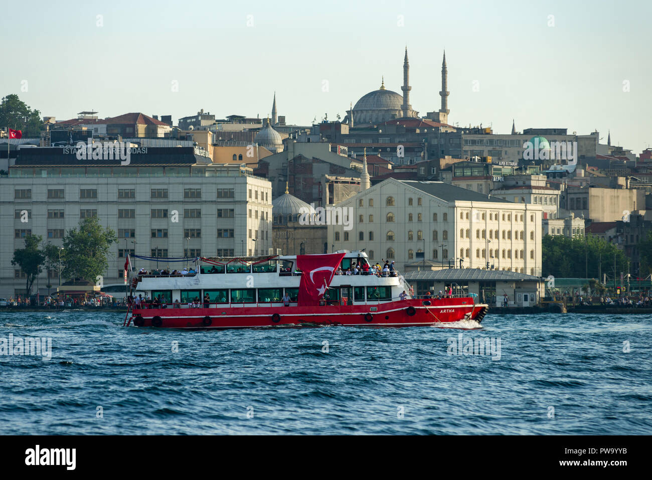 Un rosso e bianco traghetto con una grande bandiera turca su di esso la vela passato il Golden Horn, Istanbul, Turchia Foto Stock